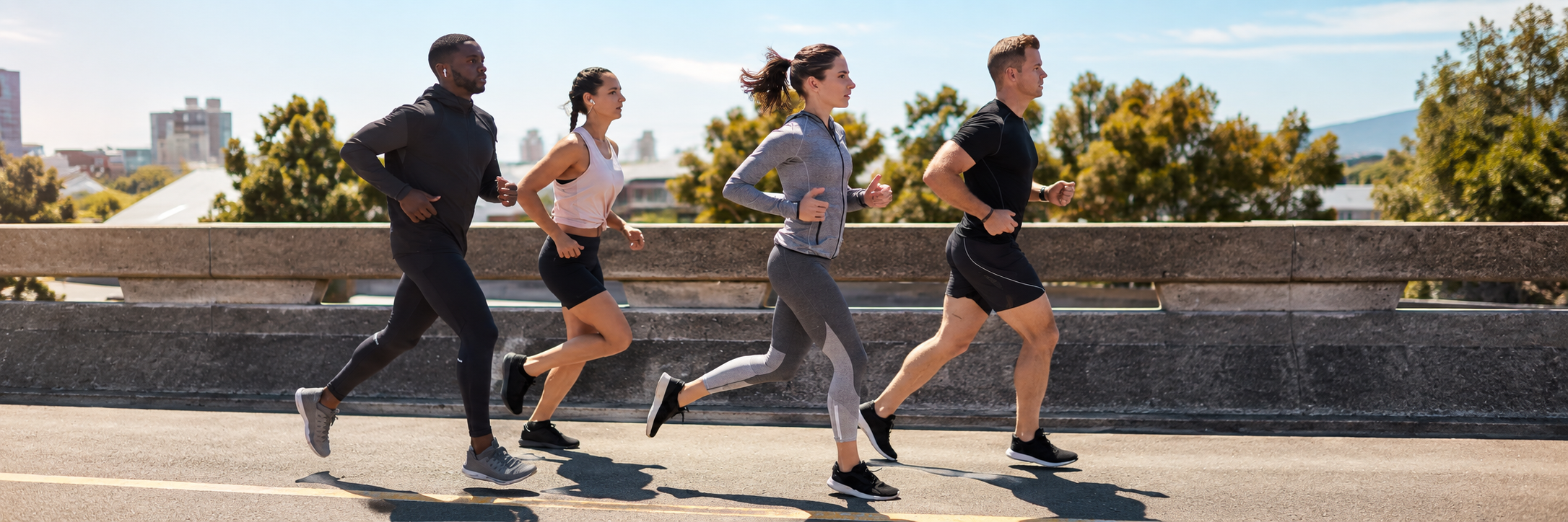 A group of friends running together on a sunny day